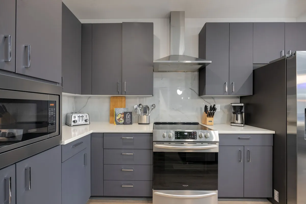 A contemporary kitchen featuring sleek, stainless steel appliances, modern cabinetry, and an uncluttered countertop, offering a bright and functional space ideal for cooking and hosting.