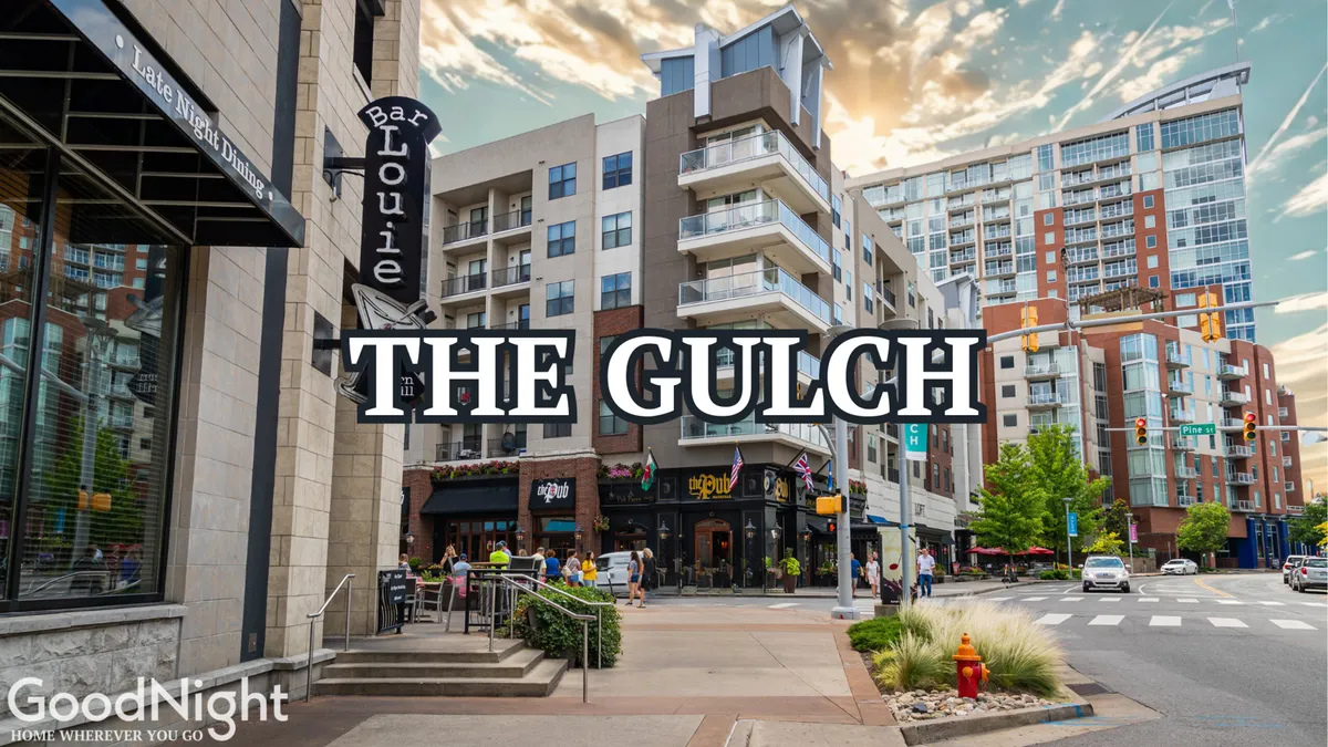 A lively street scene featuring the modern Bar Louie restaurant, apartment buildings, shops, and people walking along vibrant sidewalks. The image captures the urban convenience, energetic surroundings, and numerous dining and after-hours options within easy reach.